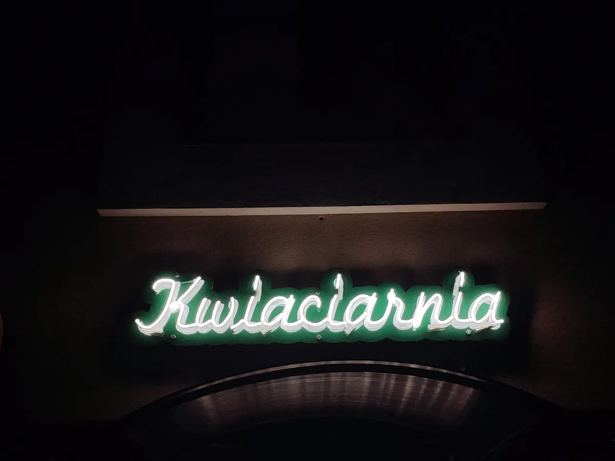 Zielony neon Kwiaciarnia nad wejściem do lokalu